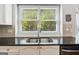 Well lit kitchen sink with granite countertop and window with verdant view at 6410 E Hills Ct, Cumming, GA 30041