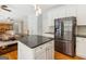 Kitchen island adjacent to the eat-in kitchen boasts black countertops and stainless appliances at 6410 E Hills Ct, Cumming, GA 30041