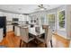 Bright kitchen with island, white cabinets, black countertops, stainless appliances and dining area with wood table at 6410 E Hills Ct, Cumming, GA 30041