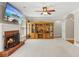 Spacious living room with a brick fireplace, built-in wooden shelving, and large windows, creating a cozy and inviting atmosphere at 6410 E Hills Ct, Cumming, GA 30041