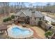 Aerial view of a backyard with a pool, deck, patio, and lush landscaping at 50 Red River Ct, Covington, GA 30014