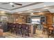 Inviting basement bar area with brick accents, wood flooring, and comfortable seating, perfect for entertaining at 50 Red River Ct, Covington, GA 30014