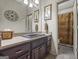 A bathroom with a dark wood vanity featuring a decorative mirror and a tiled floor with an adjacent commode at 50 Red River Ct, Covington, GA 30014