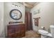 Well-appointed bathroom with a dark wood vanity, decorative mirror and a tiled floor at 50 Red River Ct, Covington, GA 30014