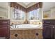 The main bathroom has a large soaking tub with decorative tile work and a beautiful view at 50 Red River Ct, Covington, GA 30014