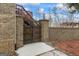 Stately brick fence with custom wood gate and lantern accents leading to backyard at 50 Red River Ct, Covington, GA 30014