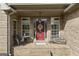 Charming covered brick front porch with seating and decorative door at 50 Red River Ct, Covington, GA 30014