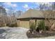 Attached garage with a driveway, surrounded by landscaped greenery and trees at 50 Red River Ct, Covington, GA 30014