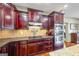 Modern kitchen featuring cherry cabinets, tile backsplash, and stainless steel appliances, perfect for cooking enthusiasts at 50 Red River Ct, Covington, GA 30014
