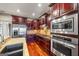 Well-equipped kitchen with stainless steel appliances, cherry cabinets, granite counters, and an island, great for meal preparation at 50 Red River Ct, Covington, GA 30014