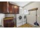 Functional laundry room equipped with cabinets, countertop, a utility sink and modern washer and dryer at 50 Red River Ct, Covington, GA 30014