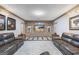 Modern living room with a brick wall feature, recessed lighting, and leather couches at 50 Red River Ct, Covington, GA 30014