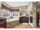Main bathroom featuring dual sinks, a soaking tub, a large picture window, and neutral tile flooring at 50 Red River Ct, Covington, GA 30014