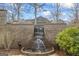 An attractive outdoor brick water feature with a small cascading waterfall and lush plantings at 50 Red River Ct, Covington, GA 30014