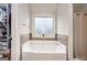 The bathroom features a large soaking tub and window with a view, complemented by tiled walls at 121 Amelia Way, Ellenwood, GA 30294