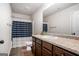 Traditional bathroom featuring wood cabinetry, a large mirror, and a shower with blue striped curtains at 121 Amelia Way, Ellenwood, GA 30294