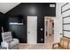 This bonus room features a dark accent wall, natural light, and offers a cozy seating area at 121 Amelia Way, Ellenwood, GA 30294
