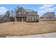 Two-story brick home featuring a covered porch and well-maintained landscaping at 121 Amelia Way, Ellenwood, GA 30294