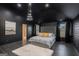 This main bedroom features dark walls, modern lighting and is completed with a grey tufted headboard at 121 Amelia Way, Ellenwood, GA 30294