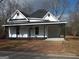 Charming home with a brick driveway, black roof, white paint and inviting covered porch at 917 Jackson St, Locust Grove, GA 30248