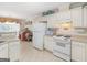 Bright kitchen features white cabinets, tile floor, and modern appliances at 506 Olivia Ct, Stockbridge, GA 30281