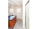 Bright bathroom featuring a marbleized sink, wood cabinets, and a shower with a glass door at 417 River Trace Dr, Villa Rica, GA 30180