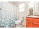 Bathroom with a toilet, sink, shower and tub combination with white and blue shower curtain at 417 River Trace Dr, Villa Rica, GA 30180