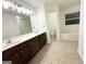 Bathroom featuring a dual sink vanity, tub-shower combo, and view into the water closet at 2517 Oakleaf Rdg, Lithonia, GA 30058