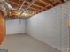 Unfinished basement area with concrete floor, white painted brick wall, and exposed ceiling at 445 Turner Dr, Mcdonough, GA 30252