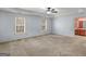 Large bedroom with neutral carpet, tray ceiling, ceiling fan, and ensuite bathroom at 445 Turner Dr, Mcdonough, GA 30252