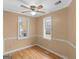 Cozy bedroom featuring fresh paint, ceiling fan, hardwood floors, and sunlit windows at 445 Turner Dr, Mcdonough, GA 30252