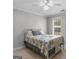 Neutral bedroom with a floral patterned quilt, ceiling fan, and natural light from window at 445 Turner Dr, Mcdonough, GA 30252