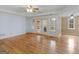 Expansive living room with hardwood floors, tray ceiling detail, and natural light from doors and windows at 445 Turner Dr, Mcdonough, GA 30252