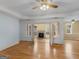 Bright living room with hardwood floors, ceiling fan, and open french doors to fireplace at 445 Turner Dr, Mcdonough, GA 30252