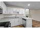 Kitchen with white cabinets, granite countertops, stainless dishwasher, and stone fireplace in background at 225 Highway 212 S, Covington, GA 30014