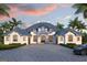 Elegant home with a cobblestone driveway, lush landscaping, and a three-car garage at 105 Godby Rd, Fayetteville, GA 30215