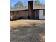 Backyard view featuring a brick chimney, patio area, and an exterior door at 1125 Carlo Sw Ct, Atlanta, GA 30331