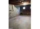 Unfinished basement with concrete block walls, exposed ceiling, and a garage door at 1125 Carlo Sw Ct, Atlanta, GA 30331