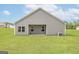 View of a backyard with ample green space and an exterior wall with window access to the inside at 1033 Claas Way, Locust Grove, GA 30248