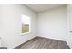 Well-lit room with hardwood floors, a window, and a door in a minimalist design at 1033 Claas Way, Locust Grove, GA 30248