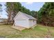 A detached garage with a white door surrounded by green trees adds extra storage to the property at 234 Thorne Wood Ln, Hampton, GA 30228