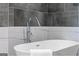 Modern bathroom with a stylish soaking tub and elegant gray and white tile surround at 567 Middle Sw St, Atlanta, GA 30310