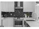 Sleek, modern kitchen with stylish black and white backsplash and stainless steel appliances at 567 Middle Sw St, Atlanta, GA 30310