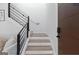 Modern staircase with wooden steps, black metal railings, and white risers, with a brown front door at 567 Middle Sw St, Atlanta, GA 30310