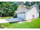 Side view showcasing a large garage with ample parking space and manicured landscaping at 3266 Greenhill Ct, Villa Rica, GA 30180