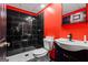 Modern bathroom features black tile walls, white fixtures, and a contrasting red accent wall at 4066 Lions Gate, Douglasville, GA 30135