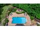 Aerial view of a pool with diving board, lounge chairs, and fire pit surrounded by lush landscaping at 709 Prestige Pt, Peachtree City, GA 30269