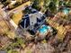 Aerial view of home featuring a backyard oasis with pool, patio, fire pit, and mature trees at 709 Prestige Pt, Peachtree City, GA 30269
