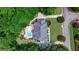 Aerial view of the backyard with pool, patio, fire pit, and lush landscaping, mature trees, and driveway at 709 Prestige Pt, Peachtree City, GA 30269