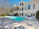 An inviting backyard oasis with a large pool and patio and comfortable outdoor seating at 709 Prestige Pt, Peachtree City, GA 30269